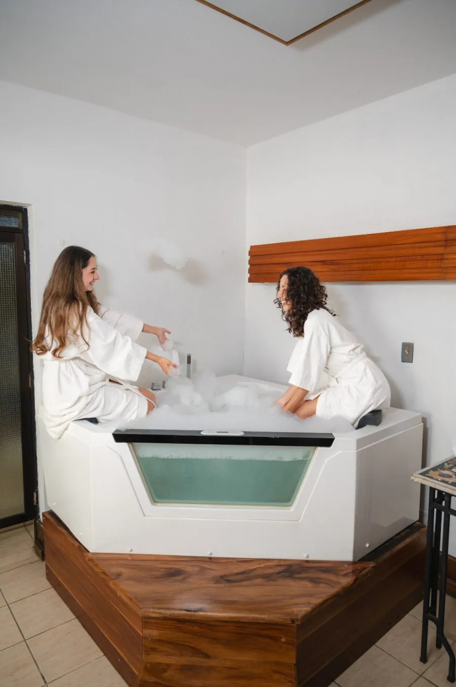 Jacuzzi con espuma y batas blancas