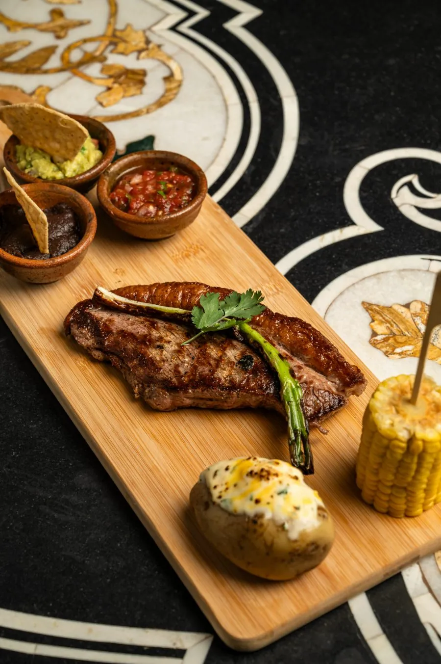 Tabla de churrasco sobre mármol con incrustaciones
