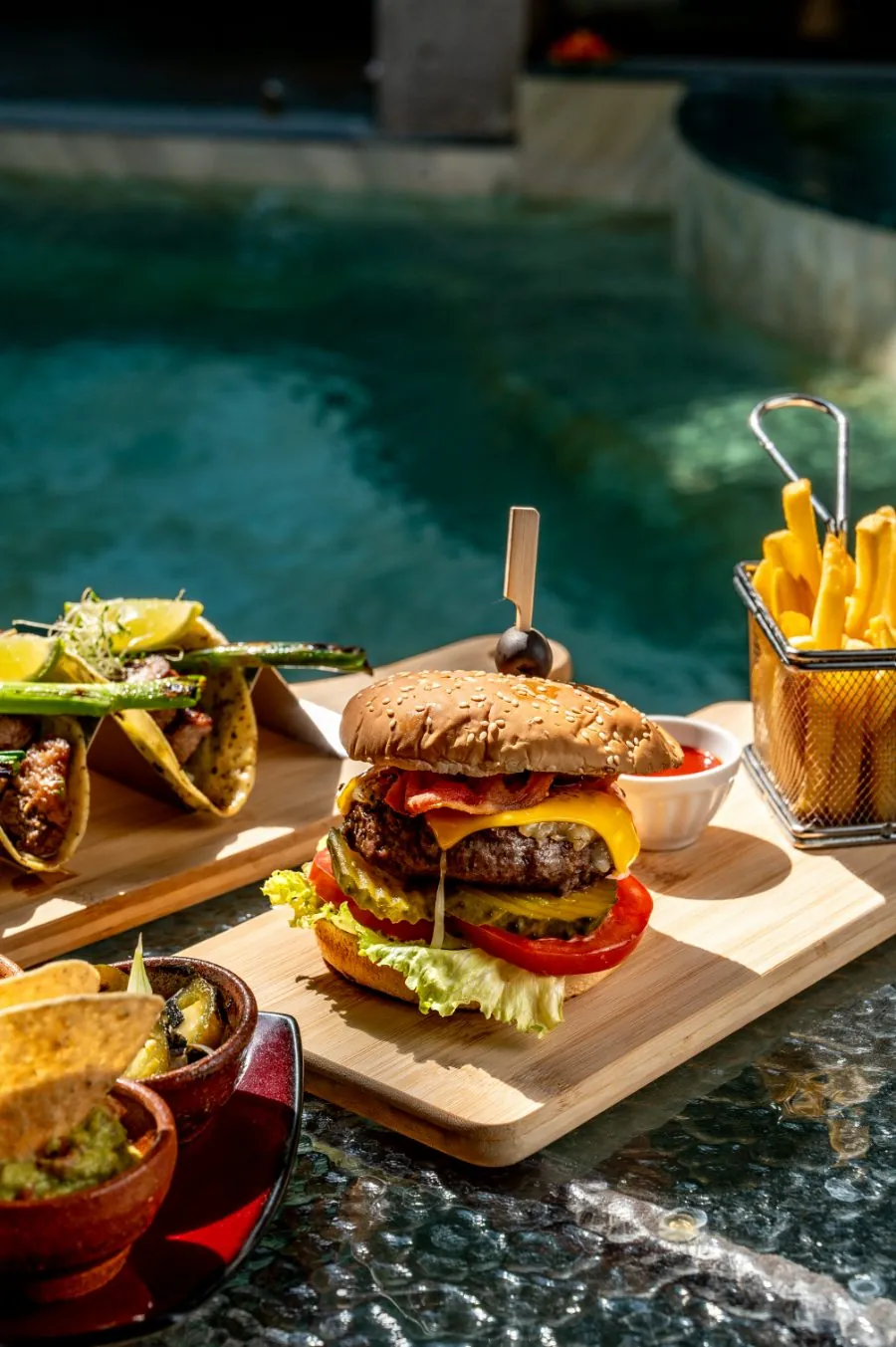 Hamburguesa y tacos junto a la piscina